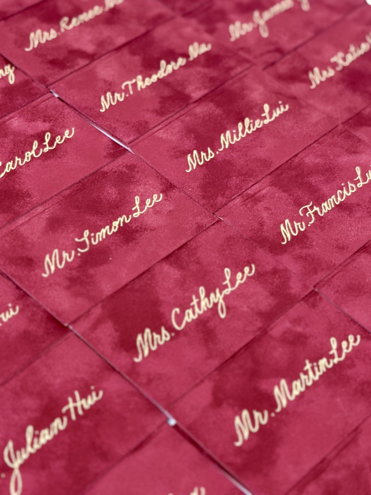 Burgundy velvet envelopes addressed in gold calligraphy for a VIP client mailing