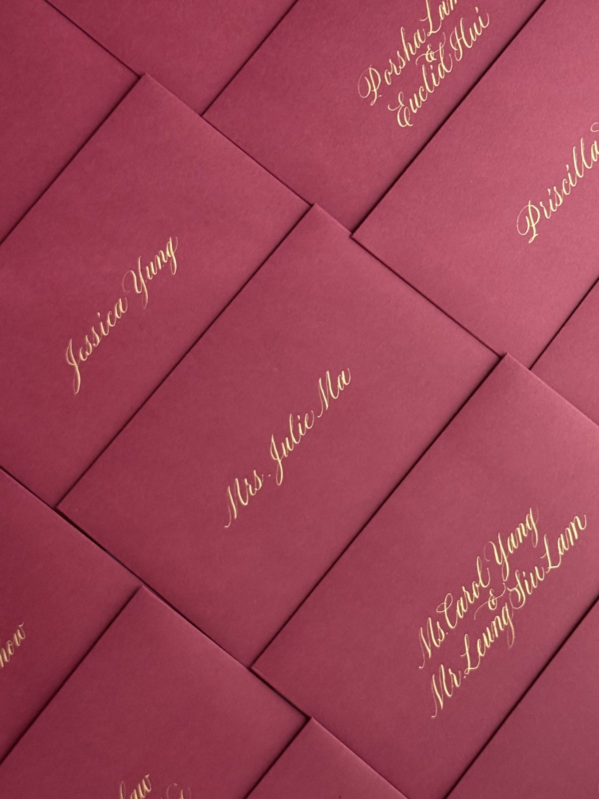 Red envelopes hand addressed in gold calligraphy for a Hong Kong corporate campaign