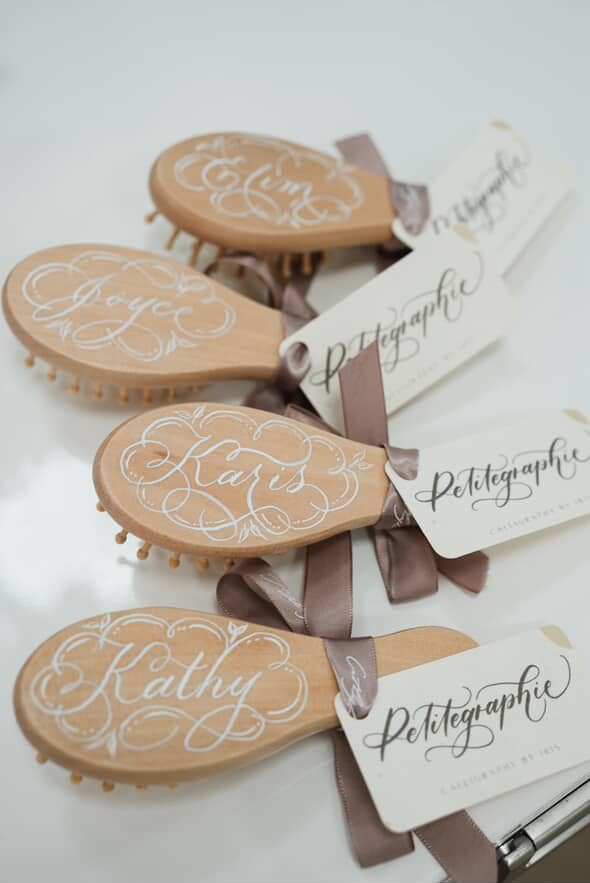 Wooden hairbrushes personalised with names in calligraphy for a brand gifting activation