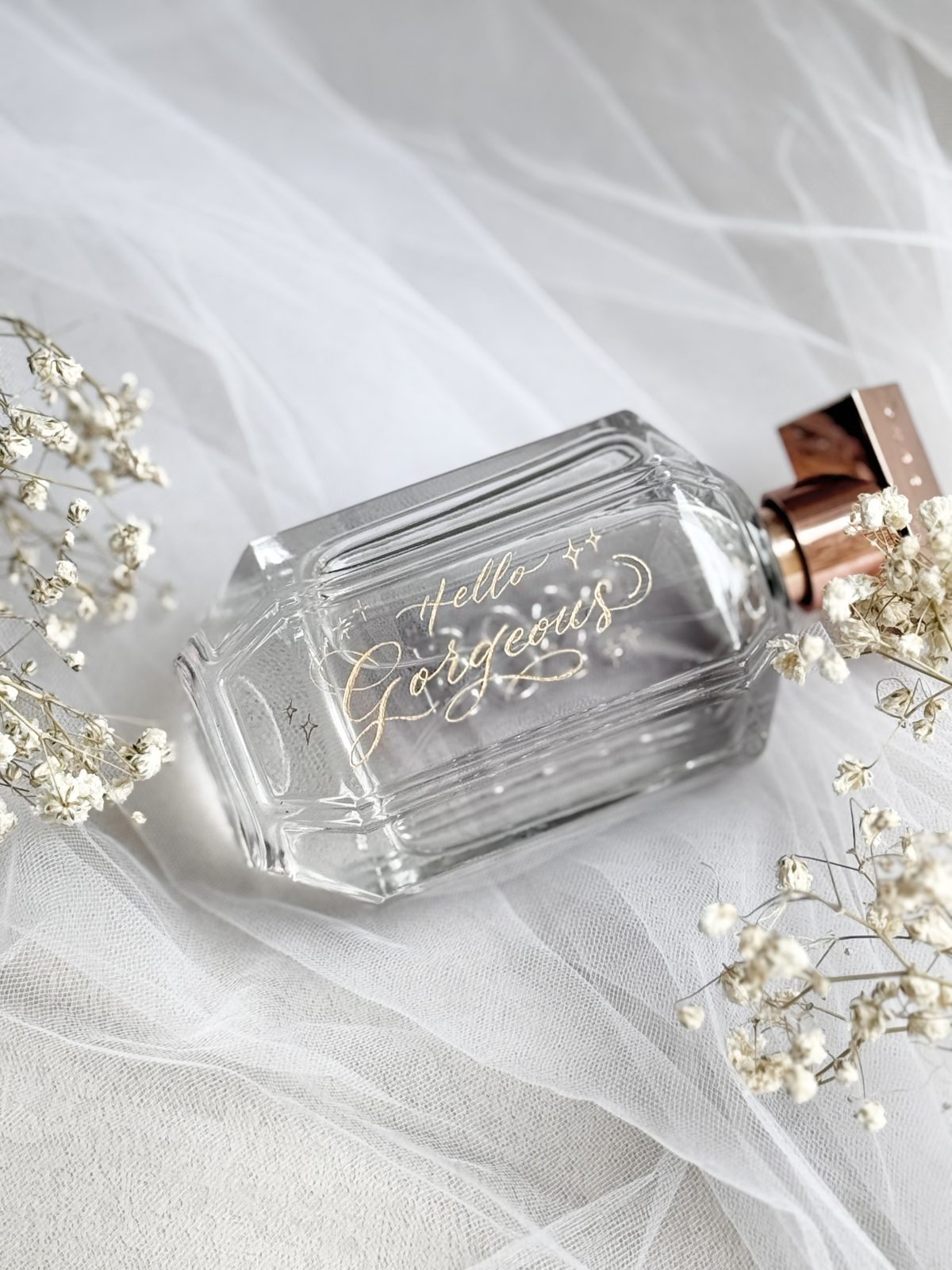 Crystal perfume bottle engraved with a name, styled with veil and baby's breath