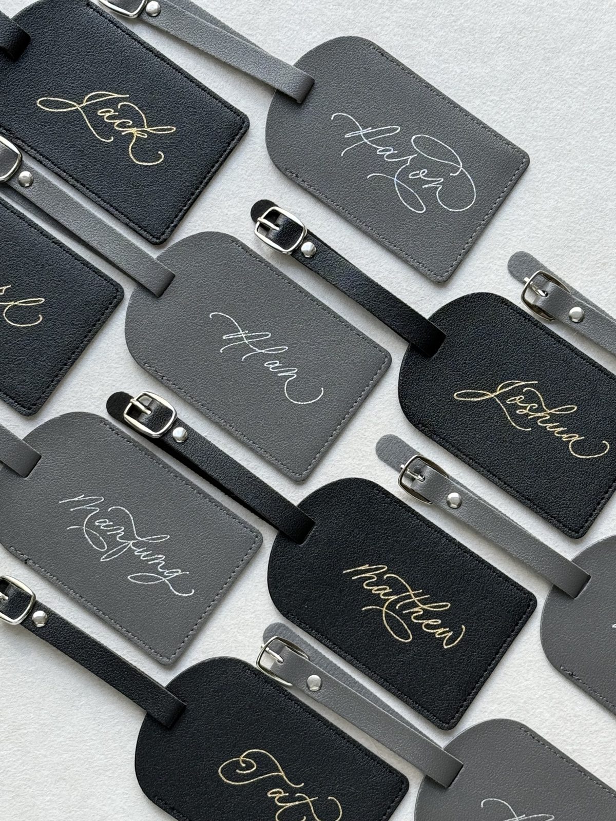 Black and grey leather luggage tags foiled with names in gold