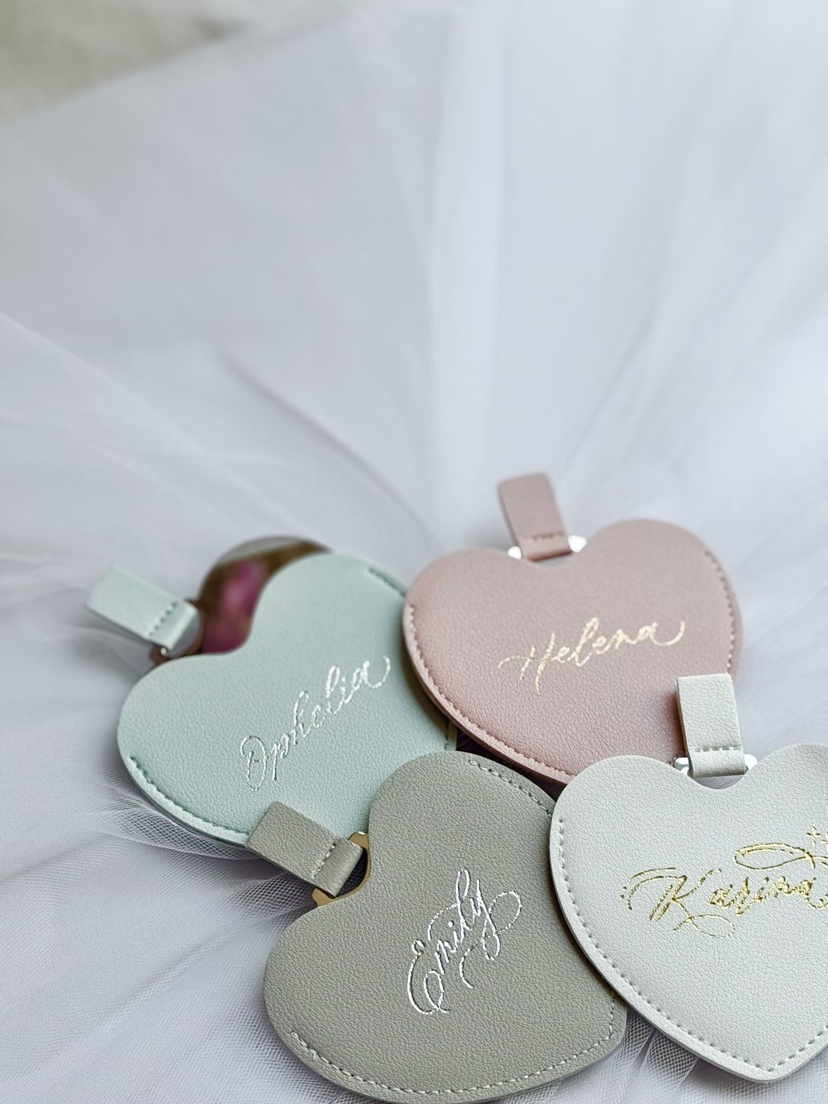 Heart-shaped leather tags foiled with names in gold on soft tulle