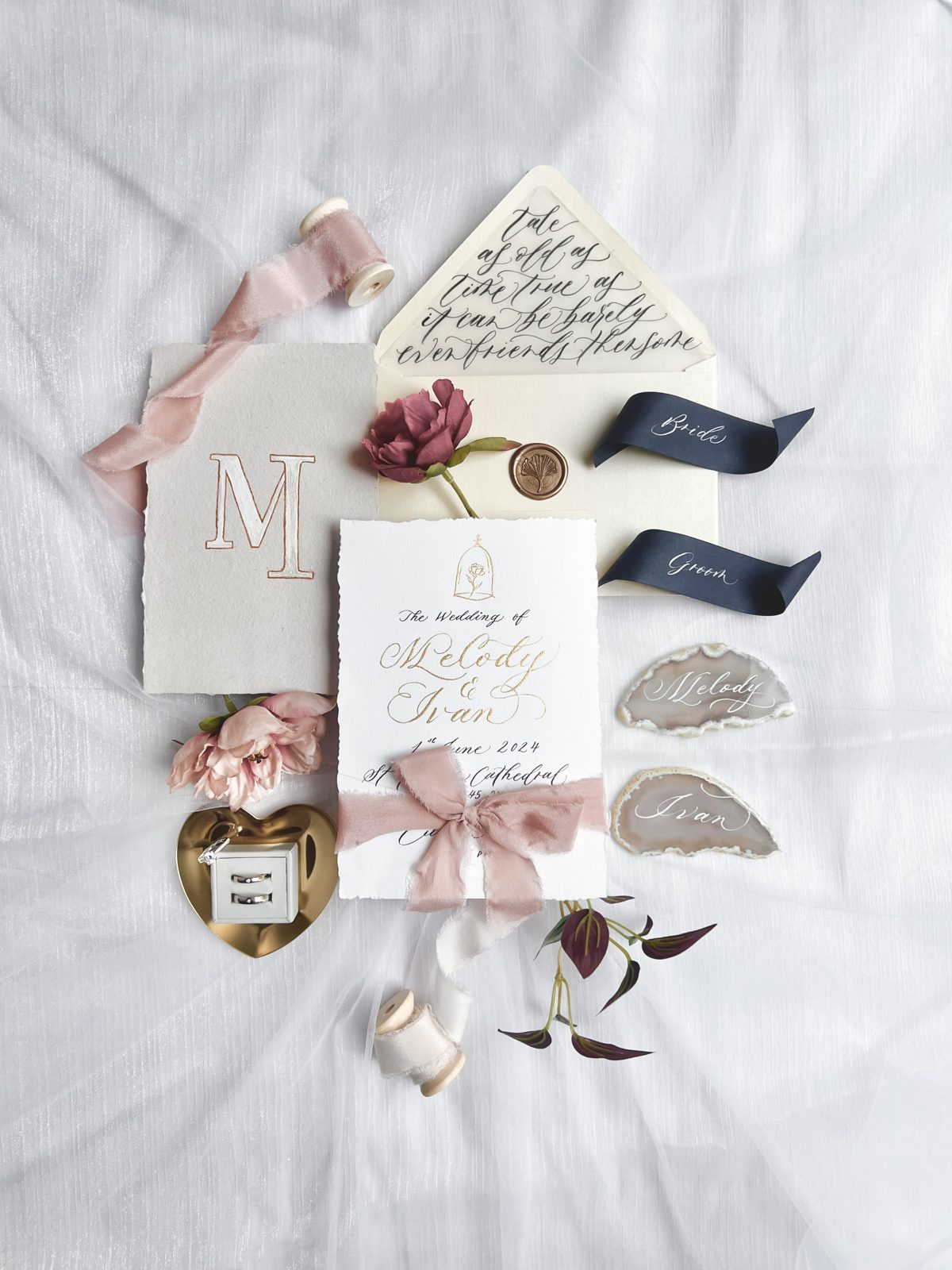 Wedding keepsake flat lay with monogrammed cards, agate slices and silk ribbon