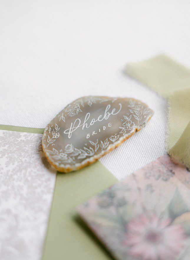 Agate slice place card with a guest name written in gold calligraphy