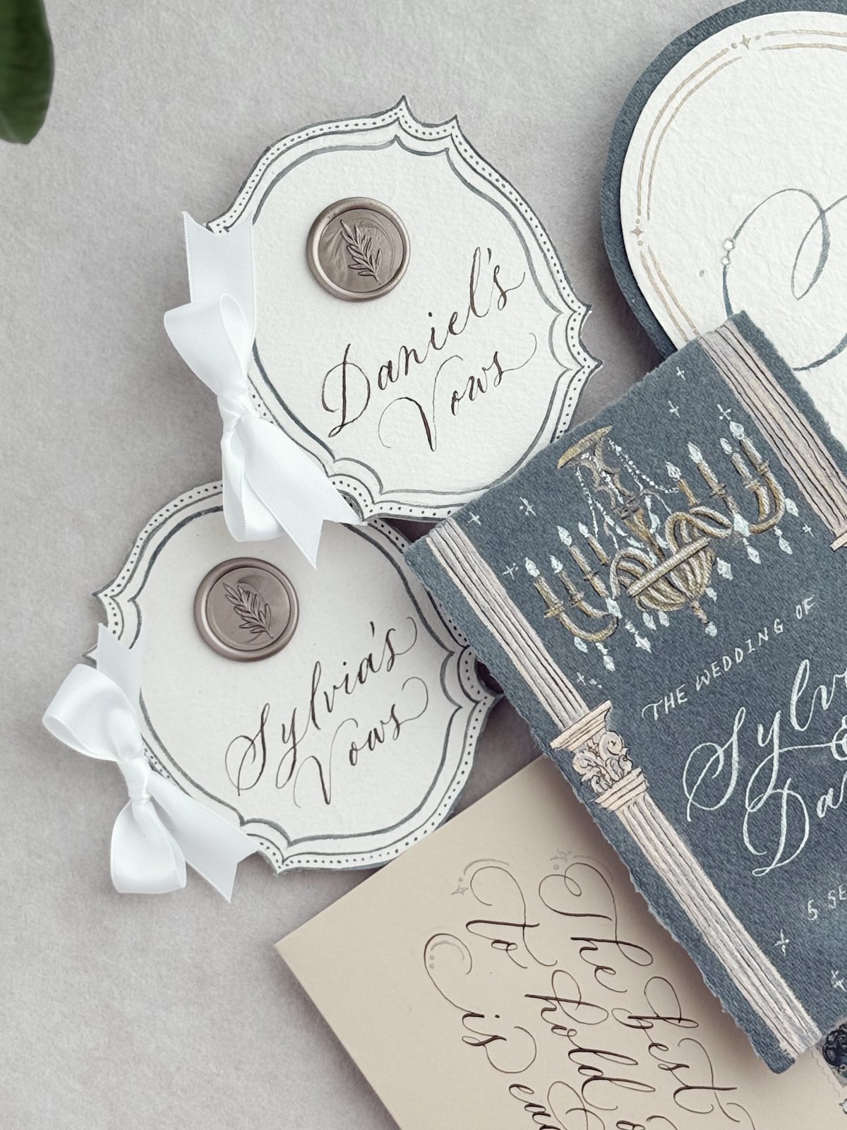 Navy and cream vow books with wax seals and calligraphed covers